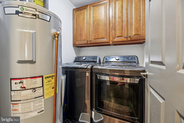 clothes washing area with cabinets, washing machine and dryer, and electric water heater