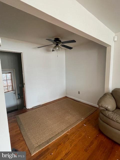 living area featuring dark hardwood / wood-style floors and ceiling fan