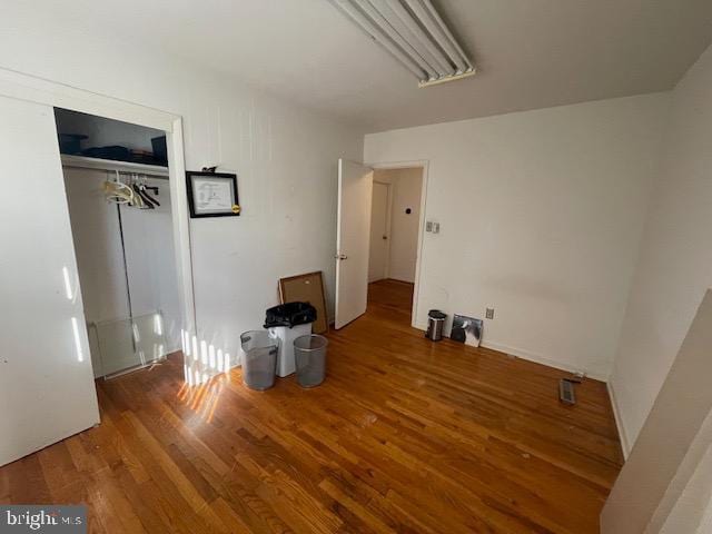 bedroom with hardwood / wood-style floors and a closet