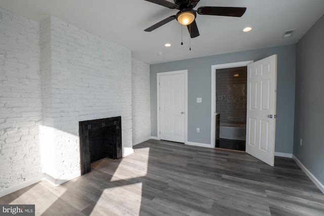 unfurnished living room with a brick fireplace, ceiling fan, and dark wood-type flooring