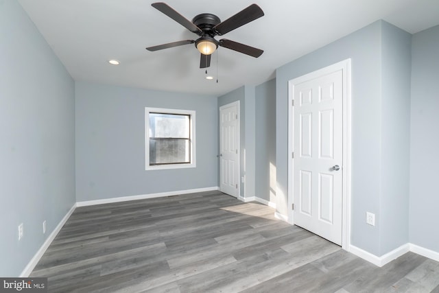 unfurnished bedroom with ceiling fan and hardwood / wood-style floors