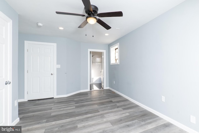 unfurnished bedroom with ensuite bath, ceiling fan, and light wood-type flooring