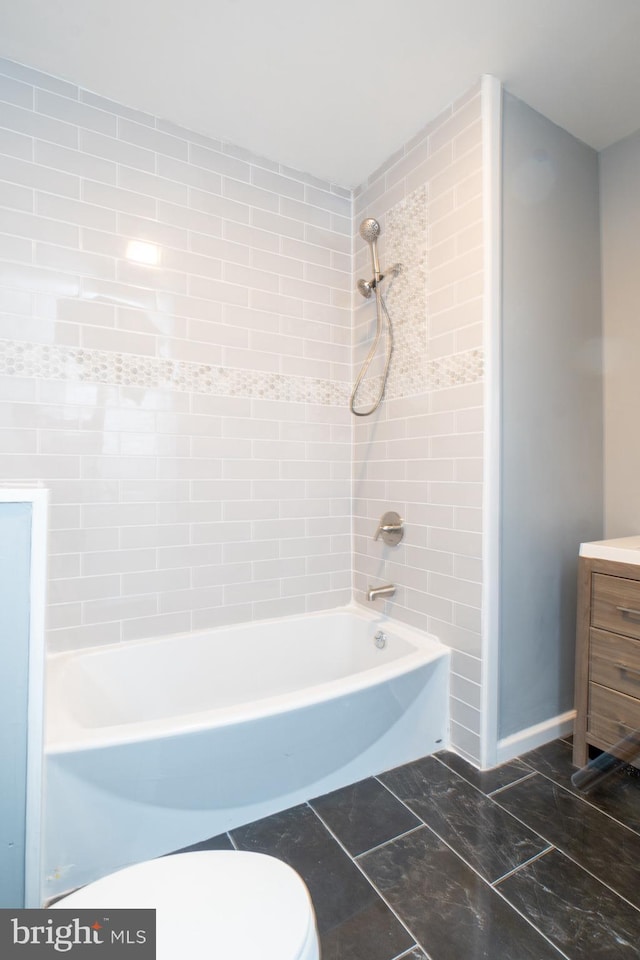 full bathroom featuring tiled shower / bath combo, toilet, and vanity