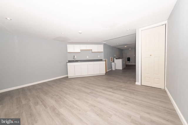 unfurnished living room featuring light hardwood / wood-style flooring and sink