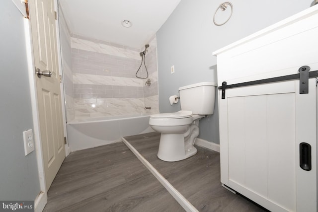 bathroom with toilet, tiled shower / bath combo, and hardwood / wood-style flooring