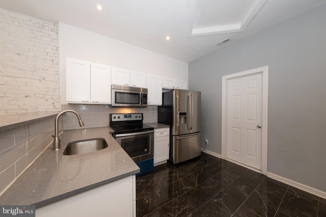 kitchen featuring sink, white cabinetry, stainless steel appliances, and tasteful backsplash