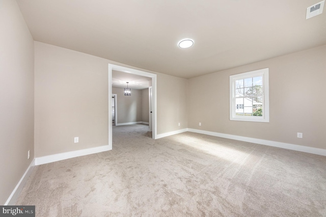 unfurnished room with carpet and an inviting chandelier