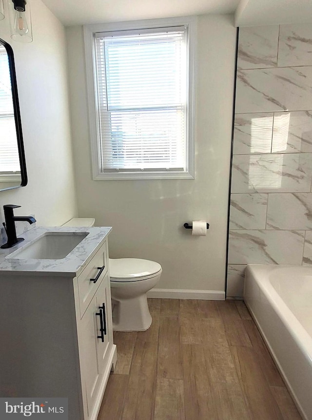 full bathroom featuring hardwood / wood-style floors, vanity, toilet, and tub / shower combination