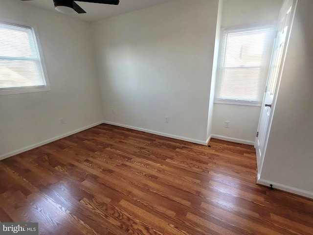 empty room featuring ceiling fan, dark hardwood / wood-style flooring, and a healthy amount of sunlight