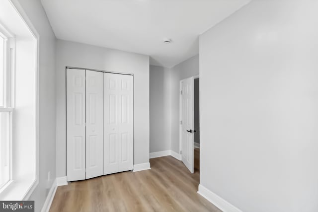 unfurnished bedroom featuring light hardwood / wood-style floors and a closet