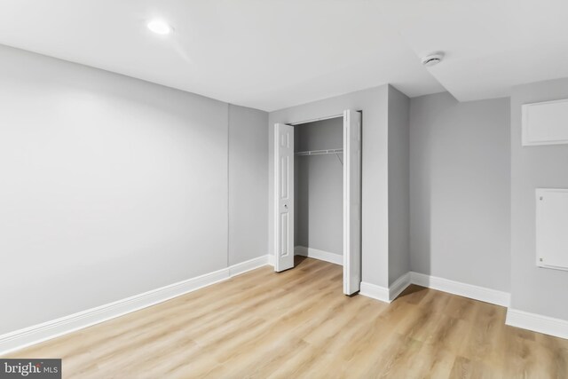 unfurnished bedroom with light wood-type flooring and a closet