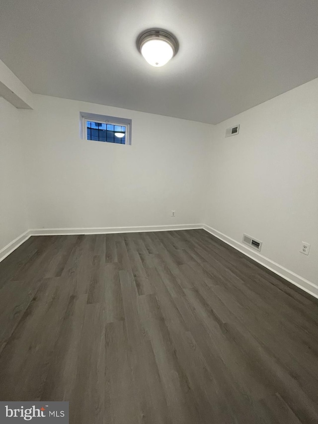 basement with dark hardwood / wood-style flooring