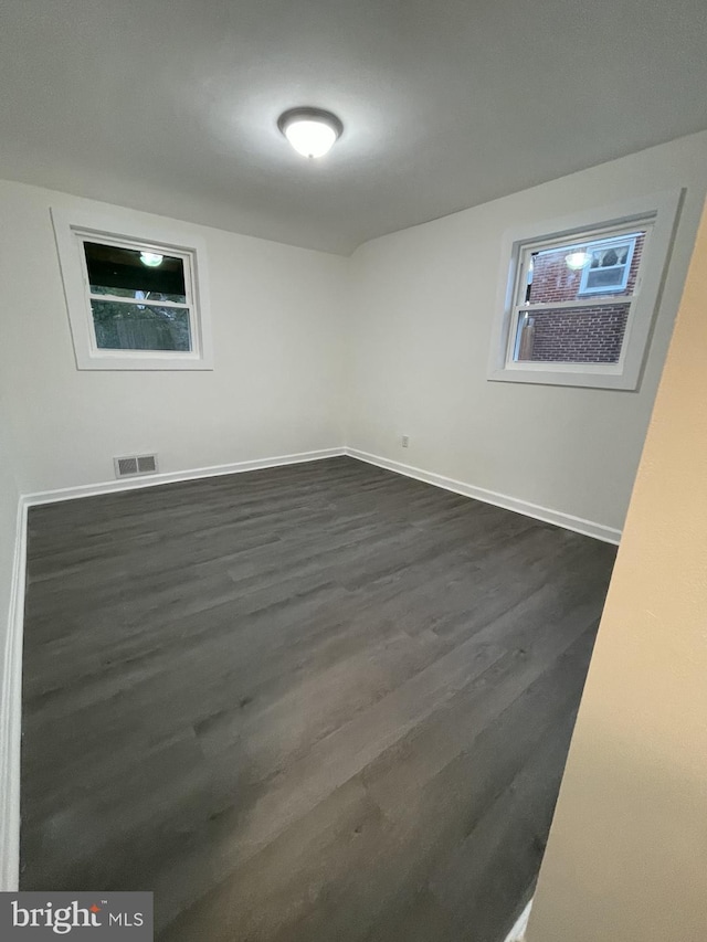 unfurnished room featuring dark wood-type flooring