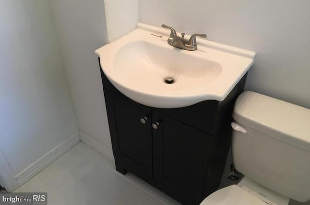 bathroom with tile patterned flooring, vanity, and toilet