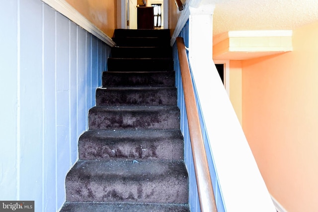 stairs with a textured ceiling