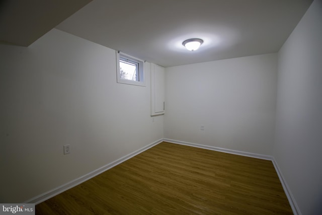 below grade area with dark wood-style floors and baseboards