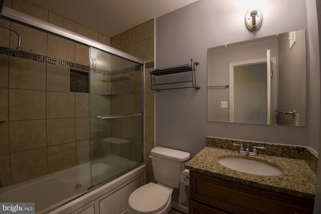 bathroom with enclosed tub / shower combo, toilet, and vanity