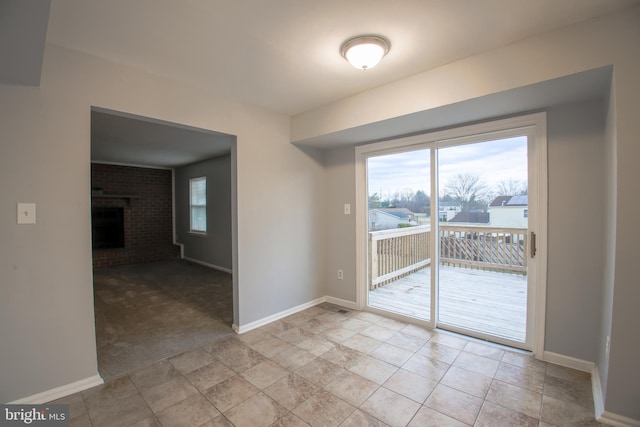 interior space featuring light carpet, a fireplace, and baseboards