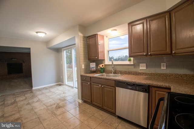 kitchen with tasteful backsplash, electric stove, dishwasher, a brick fireplace, and a sink