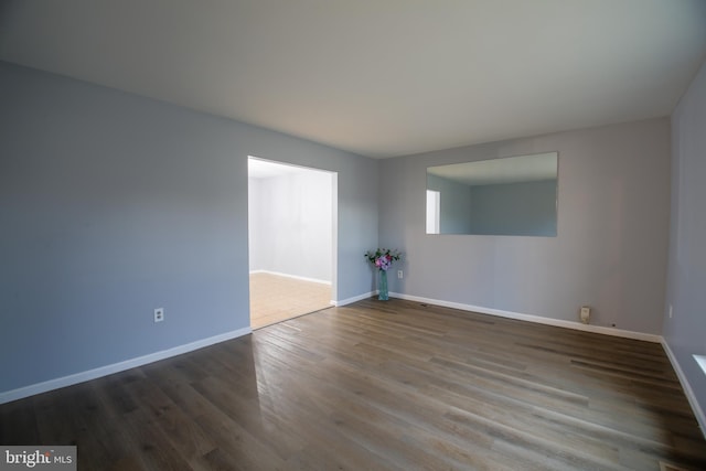 empty room featuring baseboards and wood finished floors