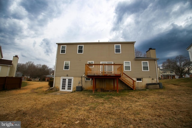 back of property with a lawn, french doors, a chimney, stairway, and a wooden deck