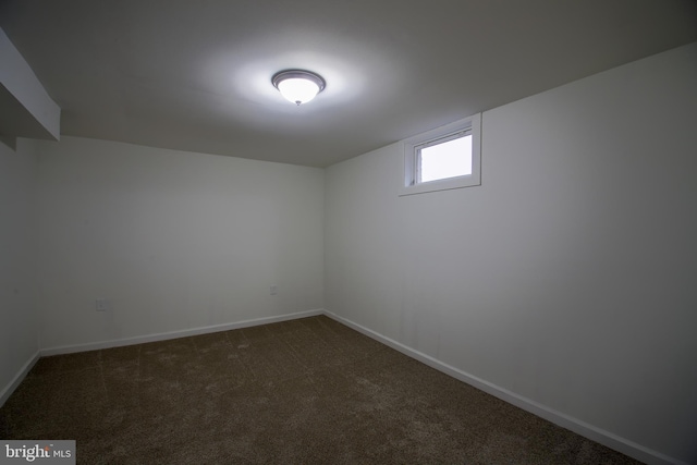 interior space with dark colored carpet and baseboards