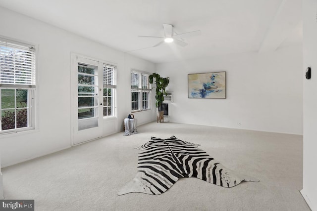 living area with light carpet and ceiling fan