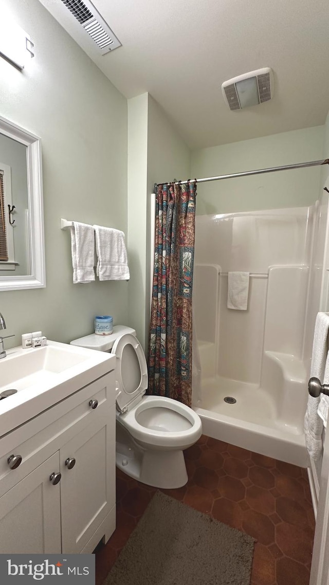 bathroom with tile patterned flooring, vanity, toilet, and curtained shower