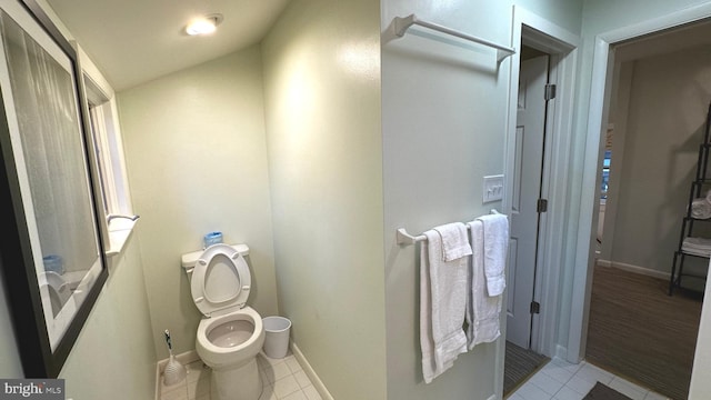 bathroom with tile patterned floors, toilet, and lofted ceiling