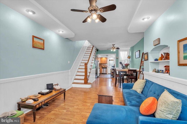 living room with light wood-type flooring and ceiling fan