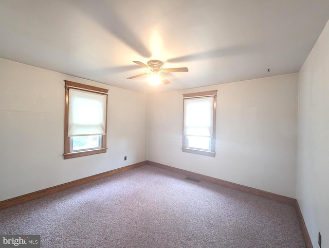 carpeted spare room with ceiling fan and a healthy amount of sunlight