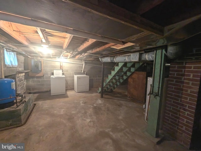 basement with electric panel and washing machine and clothes dryer