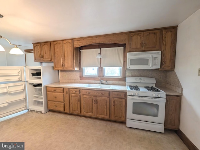 kitchen featuring white appliances, tasteful backsplash, hanging light fixtures, and sink