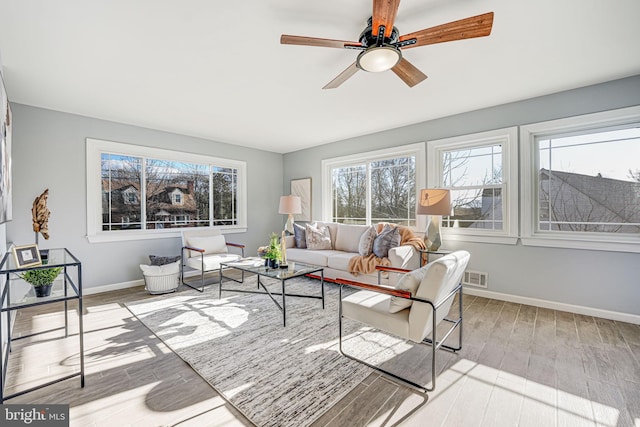 living room featuring light hardwood / wood-style flooring and ceiling fan