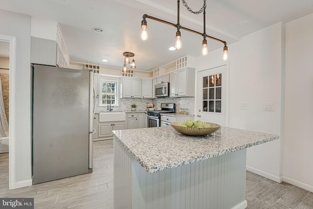 kitchen with decorative backsplash, pendant lighting, a center island, and stainless steel appliances