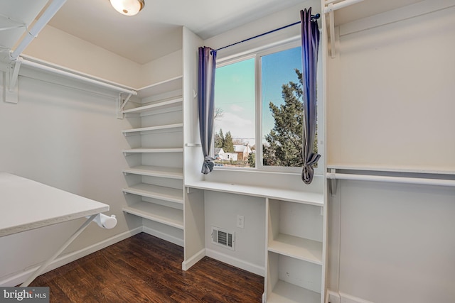 walk in closet with dark wood-type flooring