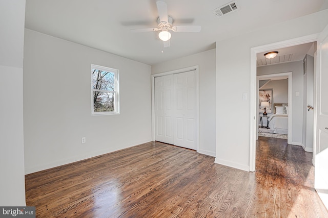 unfurnished bedroom featuring a closet, ceiling fan, and dark hardwood / wood-style floors