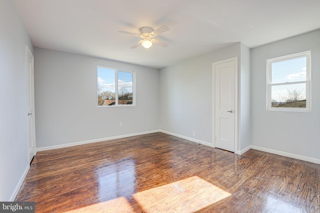 unfurnished room with dark hardwood / wood-style flooring and ceiling fan