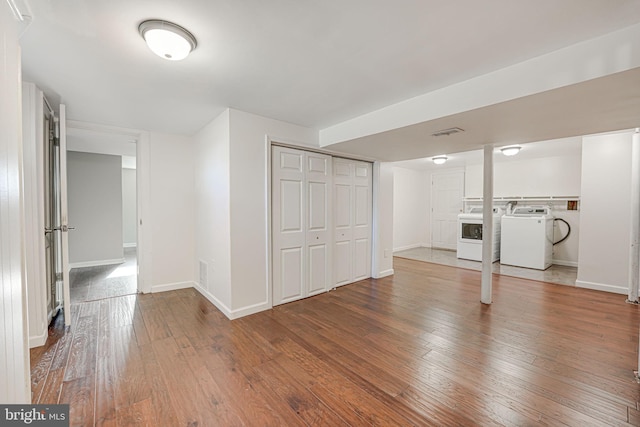 unfurnished living room with washing machine and dryer and hardwood / wood-style flooring