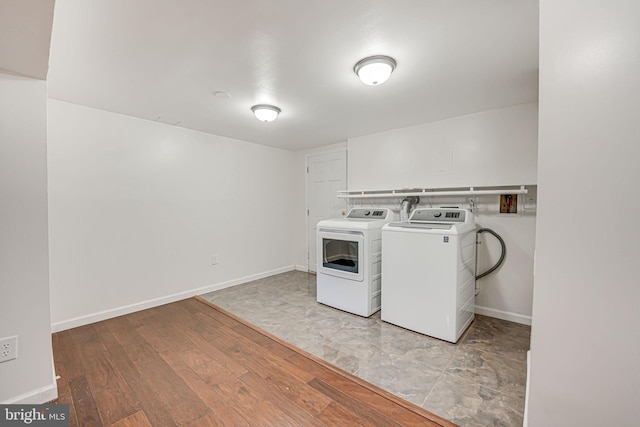 washroom with light hardwood / wood-style flooring and washer and dryer