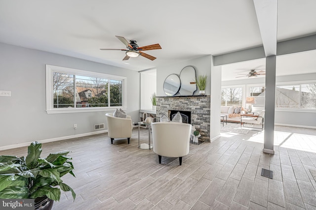 living room featuring a fireplace and ceiling fan