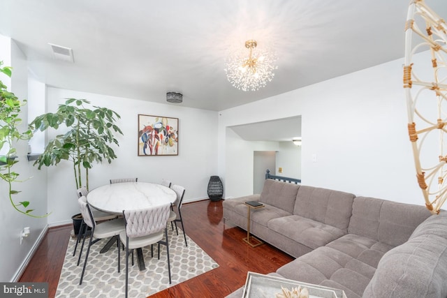 dining room with hardwood / wood-style flooring and an inviting chandelier