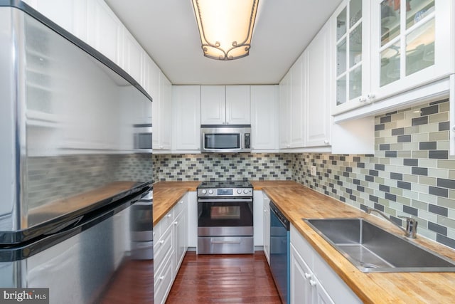 kitchen with wood counters, dark hardwood / wood-style flooring, stainless steel appliances, and white cabinetry