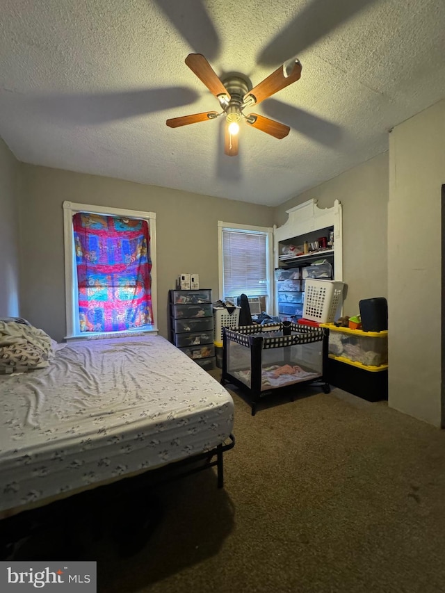 bedroom with carpet, ceiling fan, and a textured ceiling