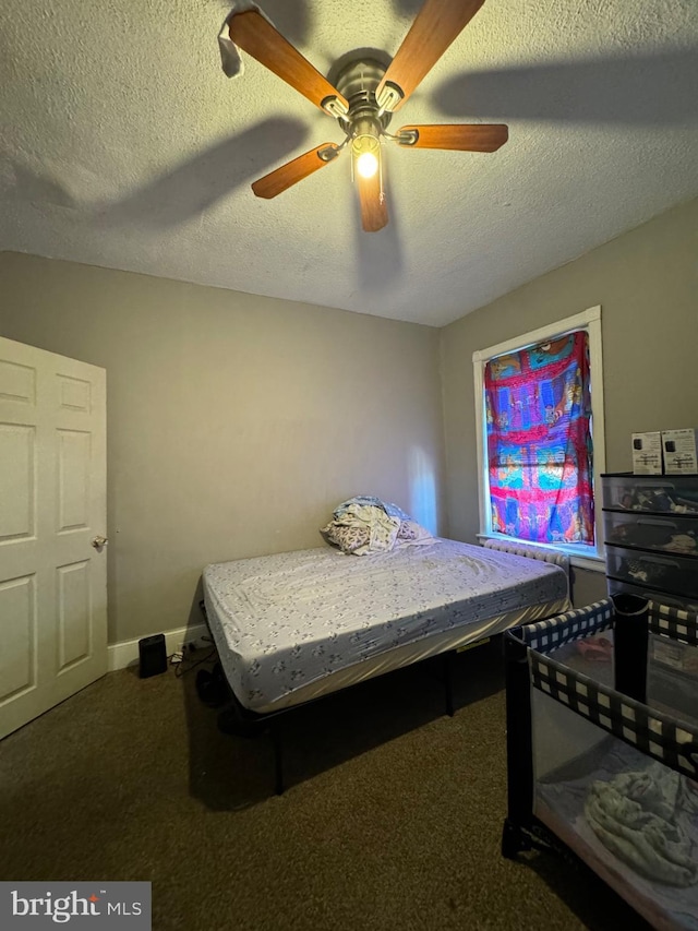 carpeted bedroom with ceiling fan and a textured ceiling