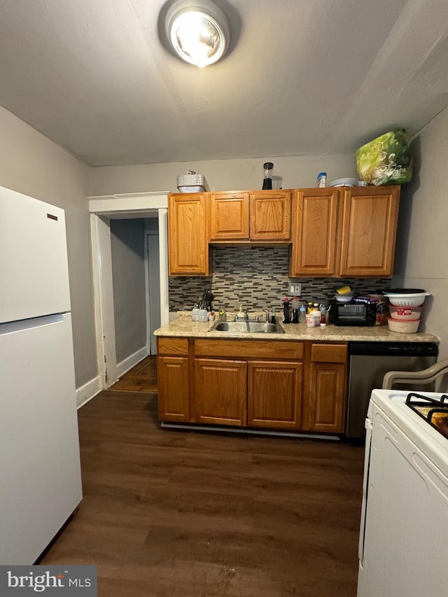 kitchen with white appliances, backsplash, dark wood-type flooring, and sink