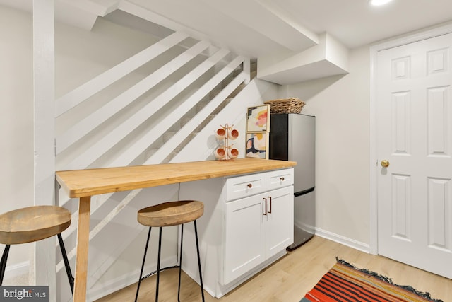 interior space featuring white cabinets, wooden counters, and light wood-type flooring