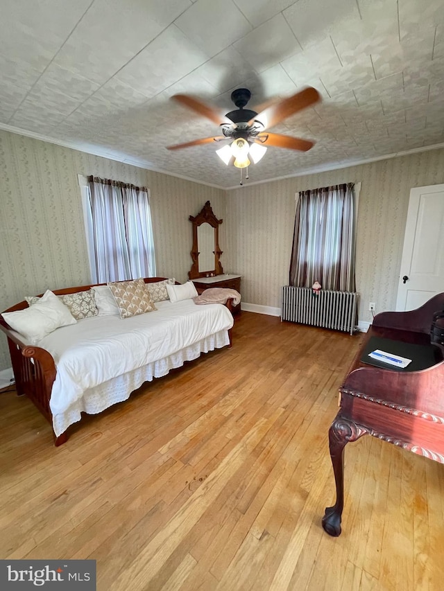 bedroom featuring radiator, ceiling fan, and light hardwood / wood-style flooring