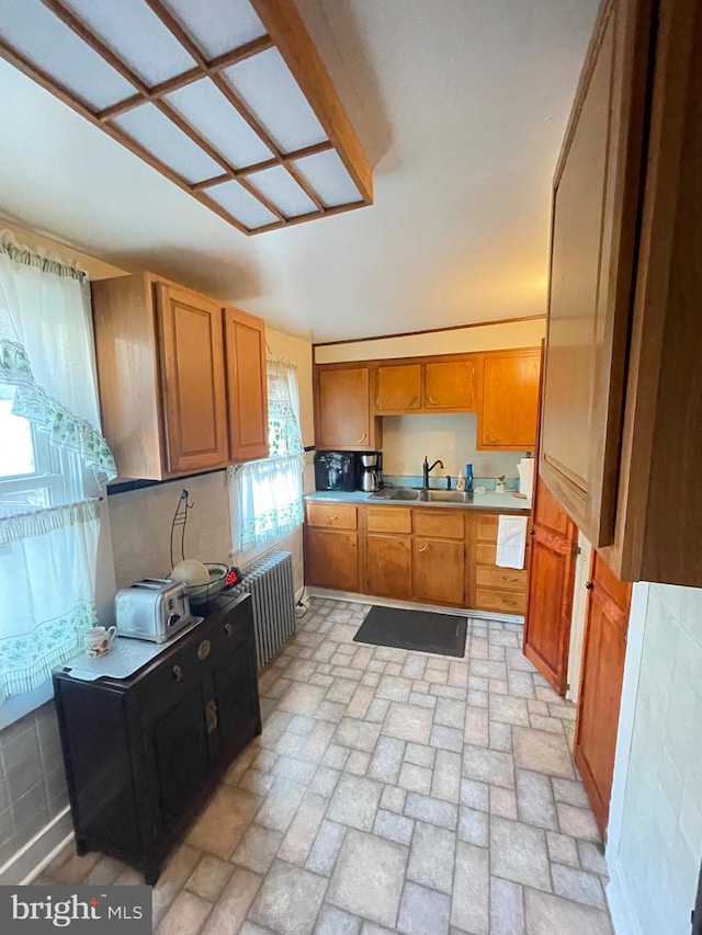 211 W 6th St, Laurel, DE 19956 - kitchen featuring radiator heating unit, brown cabinets, and brick patterned flooring