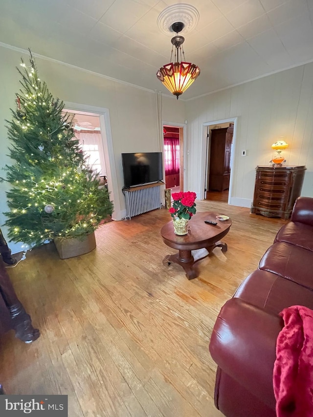 living room featuring hardwood / wood-style floors and crown molding